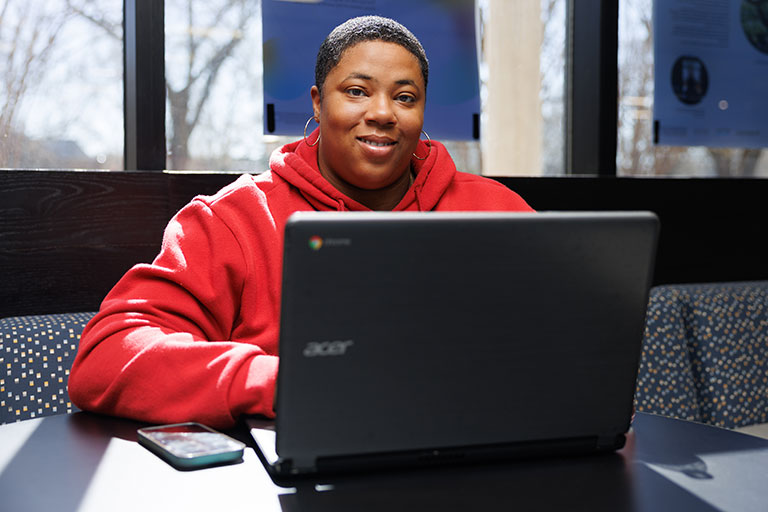 Sharrell Taylor works on her laptop at the Library